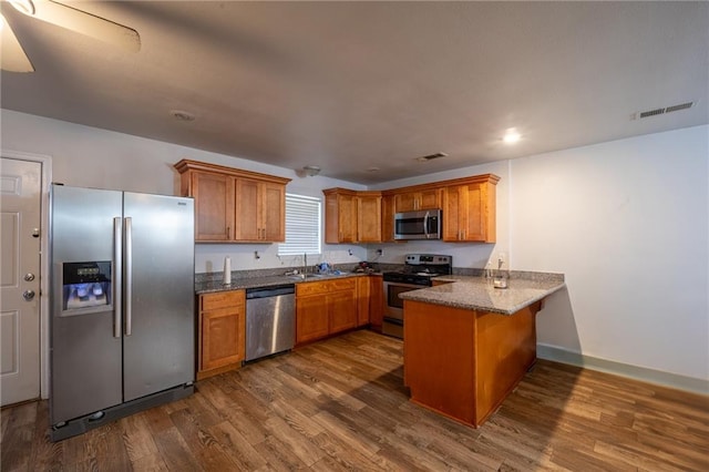 12461 Wardline Rd, Hammond, LA 70401 - kitchen with sink, dark wood-type flooring, appliances with stainless steel finishes, and kitchen peninsula