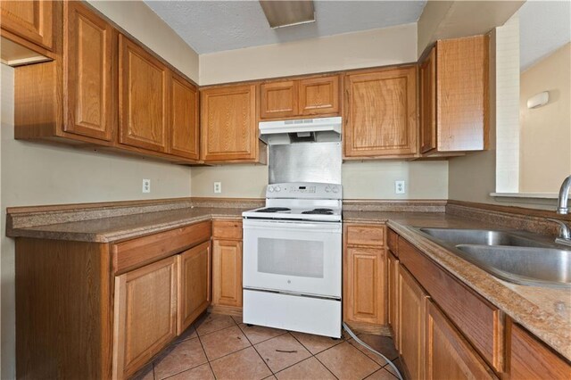 kitchen featuring sink, white range with electric stovetop, and light tile patterned floors