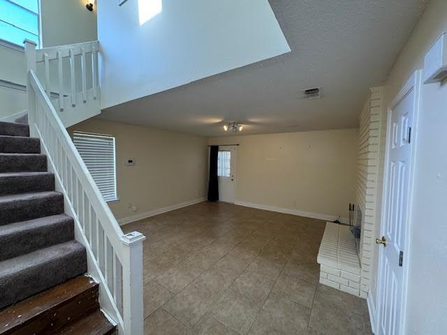 interior space featuring brick wall and light tile floors