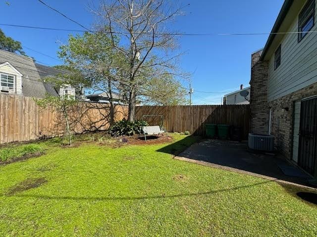 view of yard with central AC unit and a patio