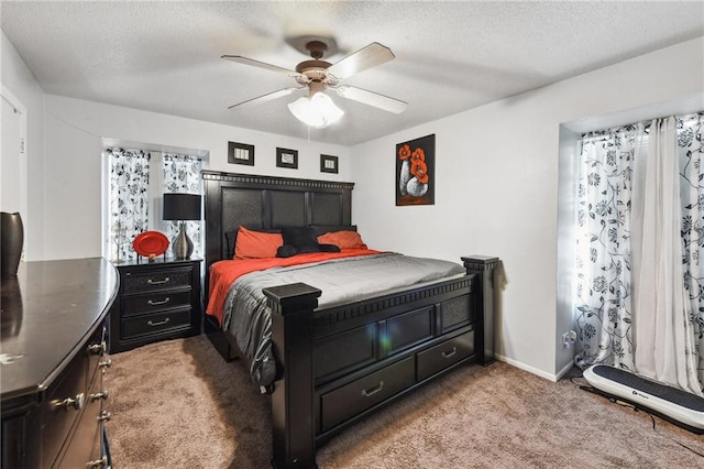 bedroom featuring a textured ceiling, light colored carpet, and ceiling fan