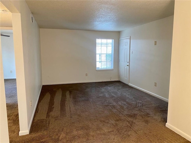 carpeted empty room featuring a textured ceiling