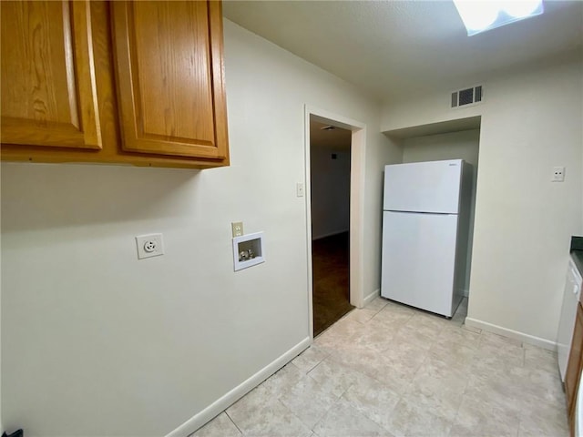 clothes washing area featuring light tile flooring, electric dryer hookup, cabinets, and washer hookup