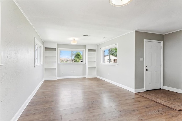 spare room featuring ornamental molding and hardwood / wood-style floors