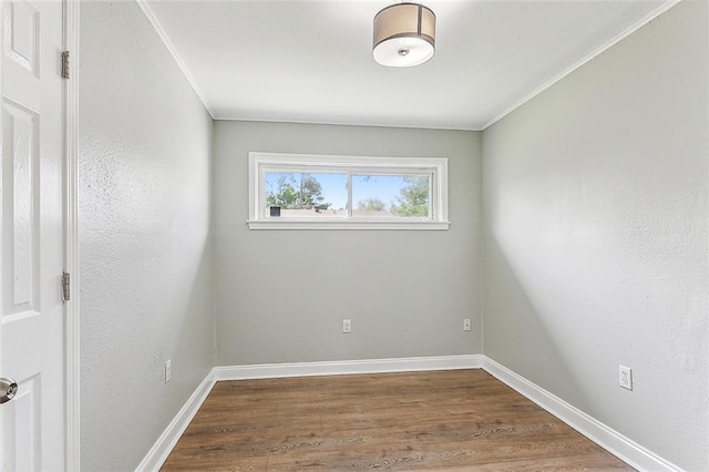 empty room with dark hardwood / wood-style floors and ornamental molding