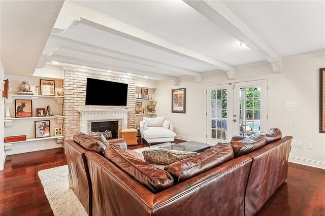 living room featuring french doors, beam ceiling, a brick fireplace, built in shelves, and dark hardwood / wood-style floors