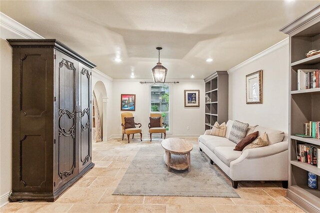 living area with a raised ceiling and ornamental molding