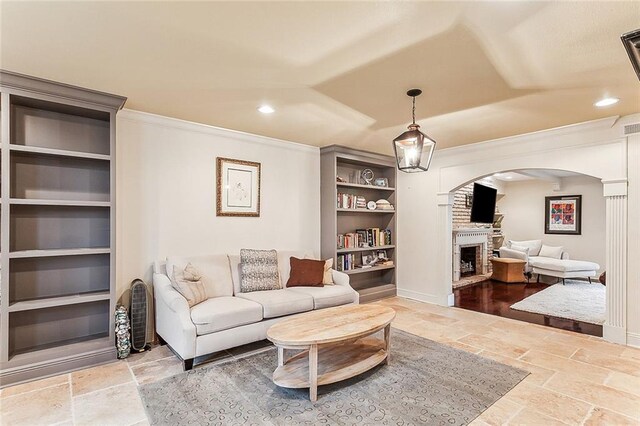 living room with built in shelves and ornamental molding