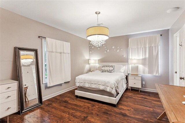 bedroom featuring a chandelier and dark hardwood / wood-style floors