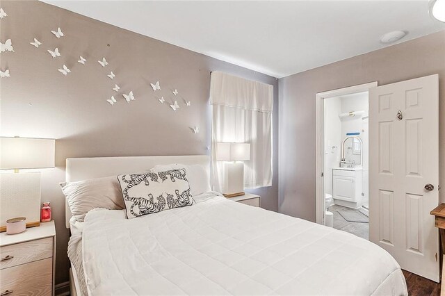 bedroom with ensuite bathroom and light hardwood / wood-style floors