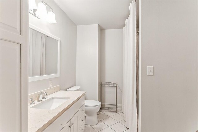 bathroom with toilet, tile patterned flooring, and vanity