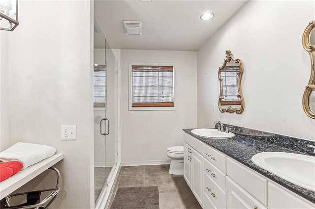 bathroom featuring vanity, toilet, and a shower with door