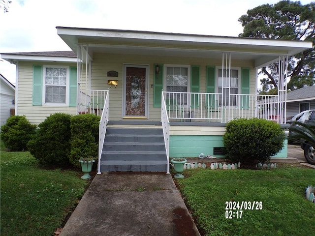 bungalow-style house with a front lawn and a porch