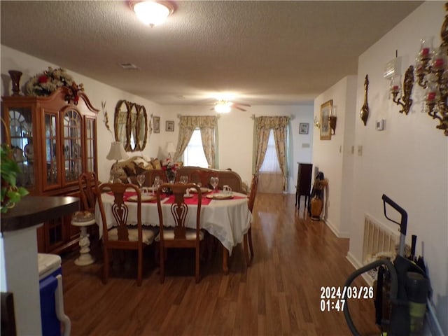 dining area featuring a textured ceiling, dark hardwood / wood-style floors, and ceiling fan