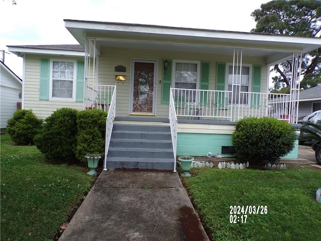 bungalow-style home with a front yard and covered porch