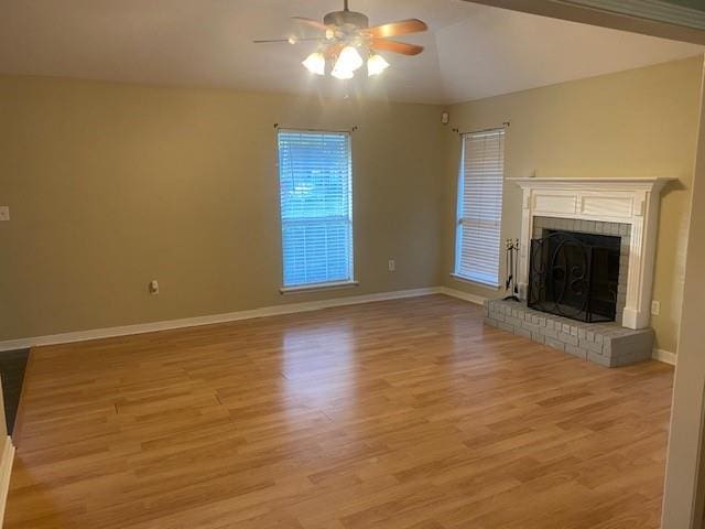 unfurnished living room with a brick fireplace, vaulted ceiling, light hardwood / wood-style floors, and ceiling fan