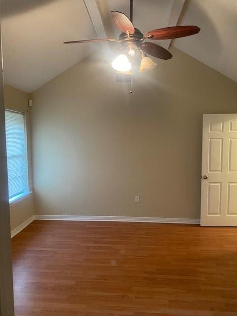 spare room featuring ceiling fan, lofted ceiling with beams, and wood-type flooring