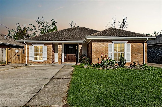 single story home featuring a lawn