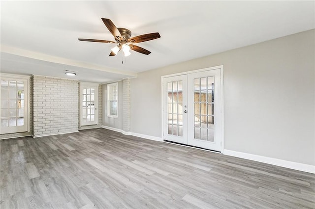 empty room with french doors, ceiling fan, and light hardwood / wood-style floors