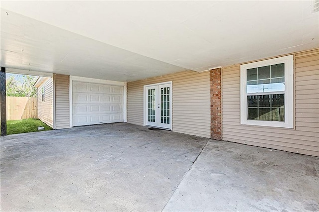 view of patio / terrace with french doors and a garage