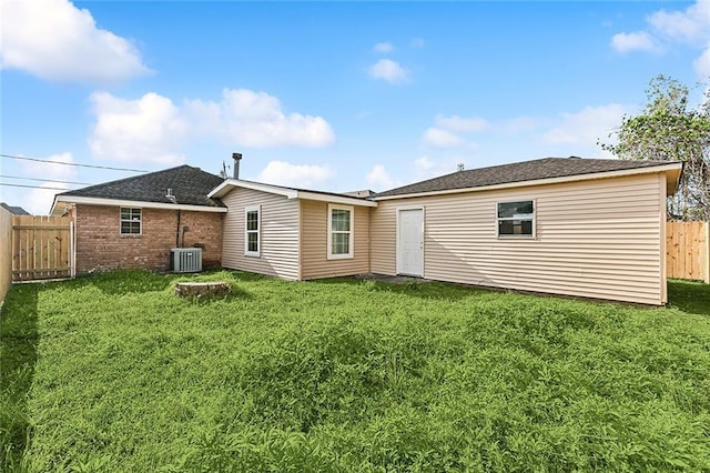 back of house featuring a lawn and central air condition unit