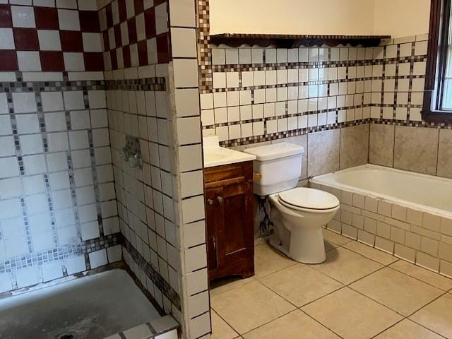 full bathroom with tile walls, toilet, independent shower and bath, and vanity