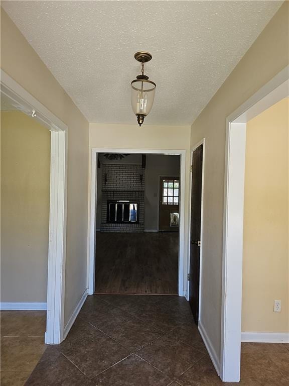 hall featuring dark wood-type flooring and a textured ceiling