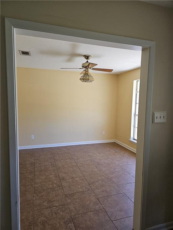 tiled empty room with ceiling fan