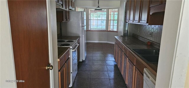 kitchen featuring dark tile patterned floors, sink, pendant lighting, stainless steel electric stove, and decorative backsplash