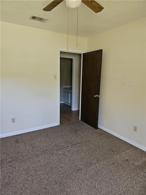 carpeted empty room featuring ceiling fan