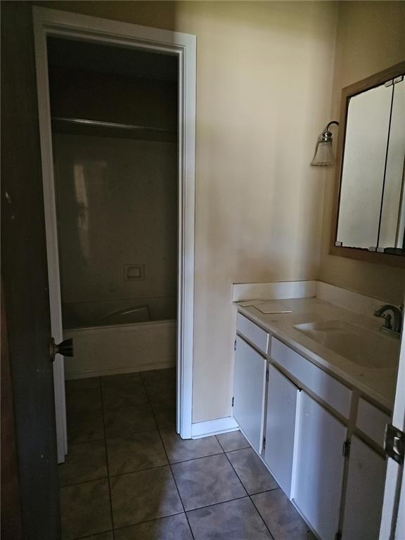 bathroom featuring vanity, tub / shower combination, and tile patterned flooring