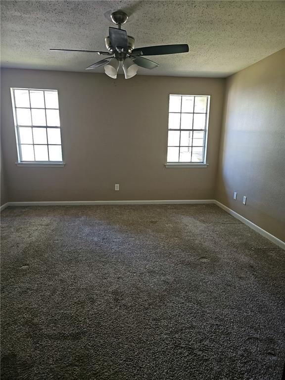 carpeted empty room with a textured ceiling and ceiling fan