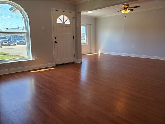 entryway featuring ceiling fan, dark wood-type flooring, and ornamental molding