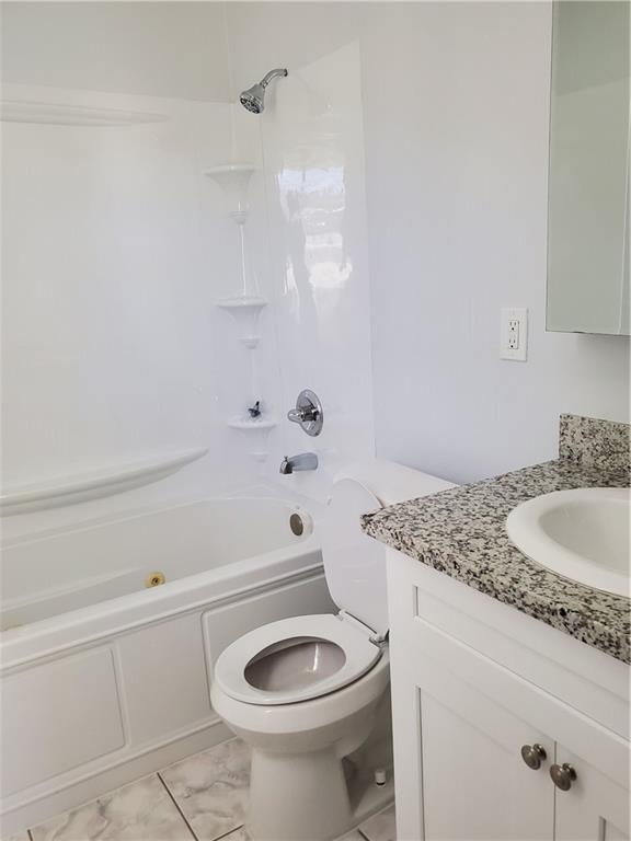 full bathroom featuring toilet, tub / shower combination, and vanity