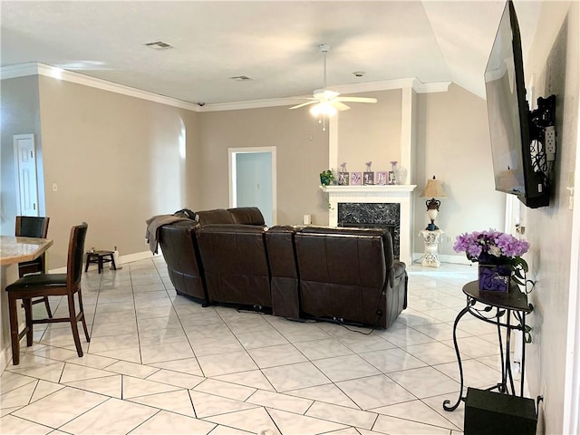 tiled living room featuring crown molding, ceiling fan, and a fireplace