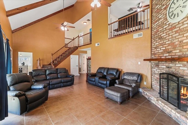 tiled living room with high vaulted ceiling, ceiling fan, and a fireplace