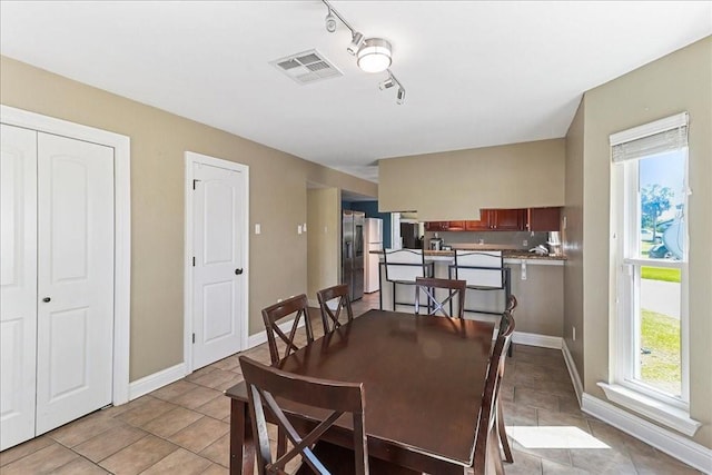 dining area featuring light tile floors and rail lighting