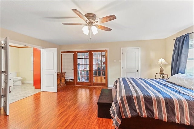 bedroom with ceiling fan, light wood-type flooring, ensuite bathroom, and french doors