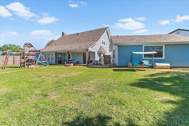 back of house featuring a playground and a yard