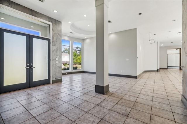 tiled spare room with french doors and a tray ceiling