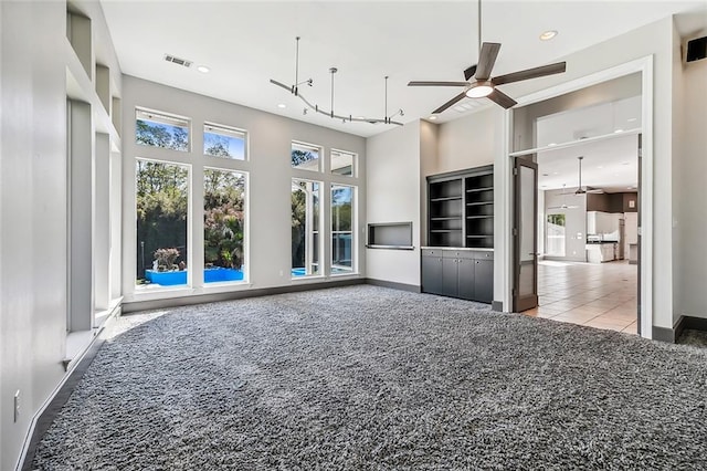 unfurnished living room with light carpet and ceiling fan