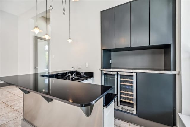 kitchen featuring a kitchen breakfast bar, sink, light tile floors, and decorative light fixtures