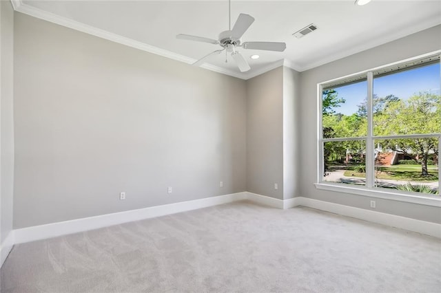 spare room with ceiling fan, crown molding, and light carpet