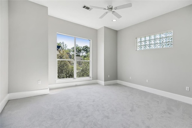 carpeted spare room with ceiling fan and a wealth of natural light