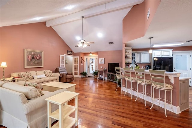 living room with beamed ceiling, hardwood / wood-style flooring, high vaulted ceiling, and ceiling fan