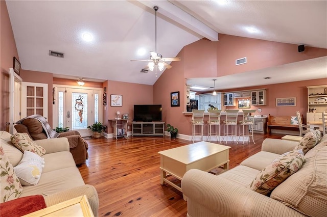 living room with beam ceiling, ceiling fan, high vaulted ceiling, and hardwood / wood-style flooring