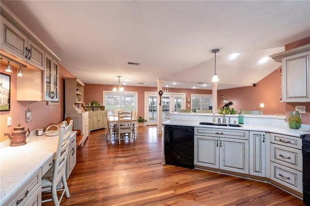 kitchen featuring dark hardwood / wood-style floors, hanging light fixtures, a notable chandelier, and black dishwasher