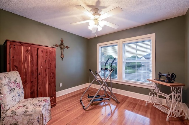 interior space with ceiling fan, light wood-type flooring, and a textured ceiling