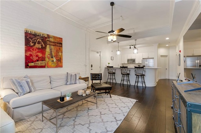 living room with ceiling fan, dark wood-type flooring, and ornamental molding