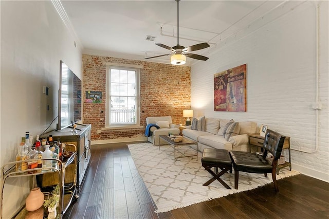 living room with ceiling fan, crown molding, brick wall, and dark hardwood / wood-style floors